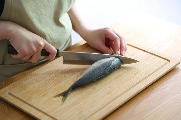 アジの鱗をとり、胸ビレと腹ビレを頭と一緒に包丁で落としたら内臓をとる。水洗いをし、水気をキッチンペーパーで拭き取る。